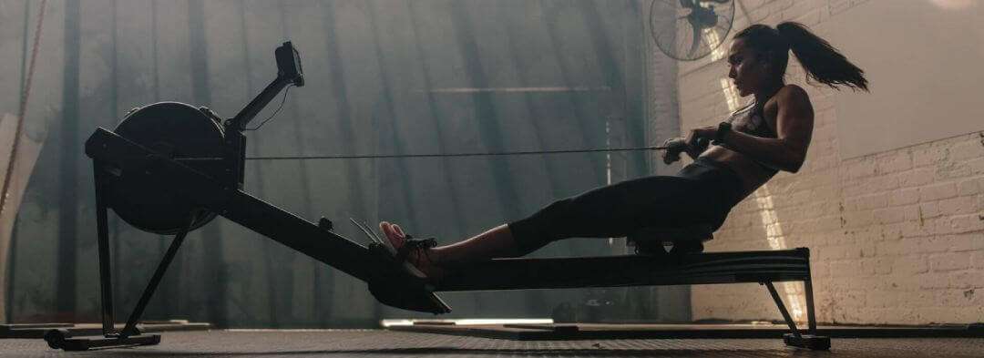Person using an indoor rowing machine to work their core and abs